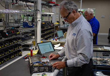 ITI Engineer working on a hardware device in the facility